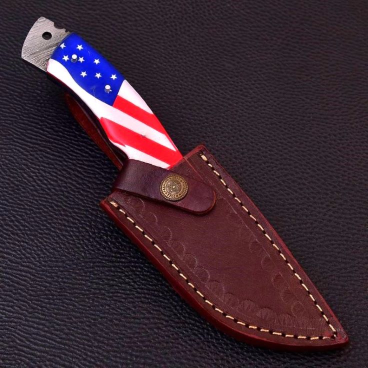 American flag handled Damascus knife secured inside premium stitched leather sheath.