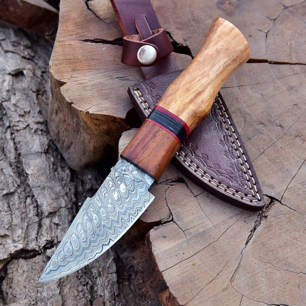 premium damascus knife laid on wood with rosewood and olive handle