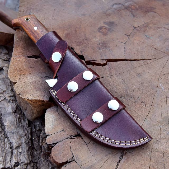 SXH1104 stainless steel tracker knife fully sheathed inside brown leather sheath with secure belt loop.